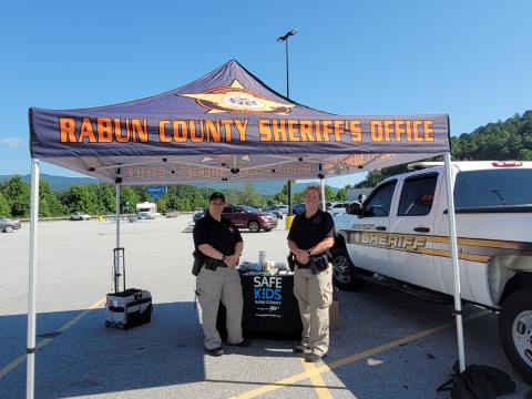 Megan Broome/The Clayton Tribune. Deputies Lisa Thompson, coordinator for Safe Kids Rabun County, and Ana Contreras conduct Car Seat Safety Checks and check seats for expiration, safety recalls, proper fit and proper installation. The technicians also educated the public about vehicle safety during the event at Walmart July 23. 
