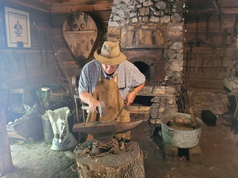 Megan Broome/The Clayton Tribune. Joe Williams demonstrates blacksmithing at the Foxfire Museum Heritage Days event in Mountain City July 8 and 9. 