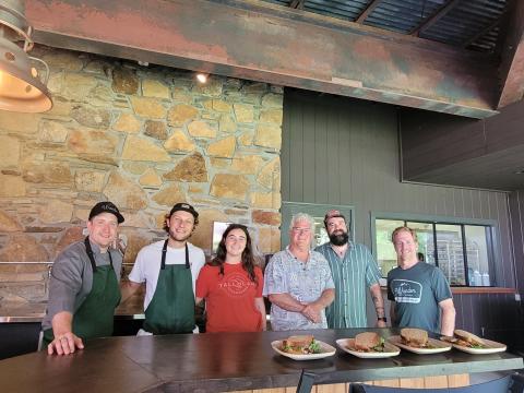 Megan Broome/The Clayton Tribune. Chef Ryne Brown, General Manager of Food Service for Tallulah Adventures, left; Kyle Jerome, Food Service Coordinator for Tallulah Adventures; Spencer Turk, operations and events manager for Tallulah Adventures; Bill Turk, owner of Tallulah Adventures; Josh Brown-co-owner of Wander North Georgia; and Jake Scott-co-owner of Wander North Georgia open Tallulah Adventures and the second location of Wander North Georgia to members of the public.