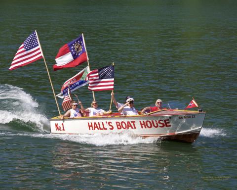 Photo courtesy of KA Hamdy-Swink. The “Hall’s No. 1” 1957 Chris Craft Sportsman 20’ owned by Thad and Darlene Warren sails down Lake Rabun during the Wooden Boat Parade. 