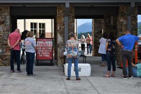 Enoch Autry/The Clayton Tribune. Those who attended on July 30 pray outside the primary school.