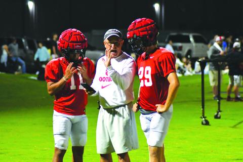 Enoch Autry/The Clayton Tribune. Coach CJ Stockel directs players as it approaches 1 a.m. on Aug. 1 at the Proving Ground practice field. In the background, fans line the sidelines at the high school to watch the 2022 version of the Wildcats.
