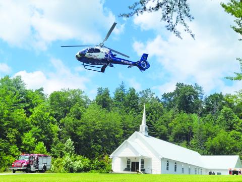 Megan Broome/The Clayton Tribune. Emergency personnel work the LZ site located at Pleasant Hill Missionary Baptist Church as the patient is transported by AIRLife following a single motorcycle crash on Warwoman Road Aug. 13. 