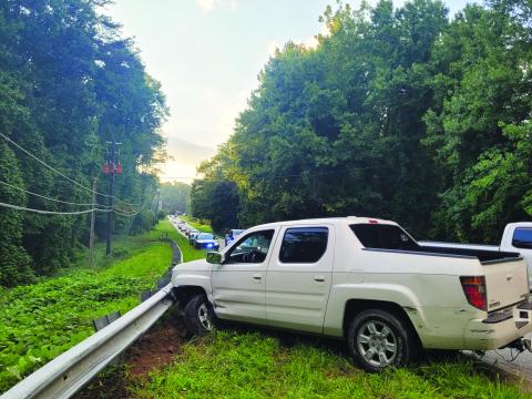 Megan Broome/The Clayton Tribune. Rabun County emergency personnel work the scene of a single vehicle crash on Highway 76 east just before the intersection of Old Chechero Road in Clayton on Aug. 15. A Rosman, N.C., man experienced a medical emergency prior to crashing into a guardrail. 