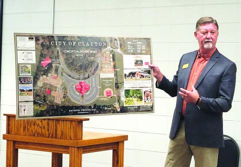Megan Broome/The Clayton Tribune. Clayton Mayor Kurt Cannon unveils plans for the proposed new complex on the city’s 18-acre property at a city council meeting in August. Plans are to have a new city hall, theater, gardens, and concert area.