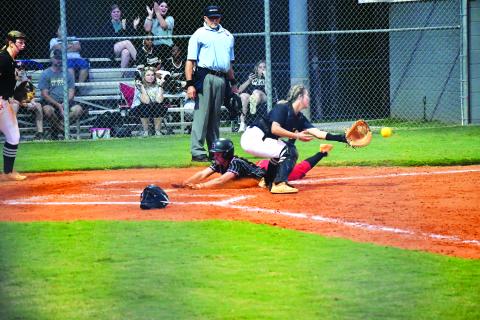 Luke Morey/The Clayton Tribune. Junior Mili Watts slides into home plate for an in the park home run.