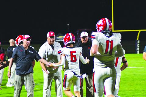 Enoch Autry/The Clayton Tribune. Senior Jaden Gibson (6) receives congratulations from the Wildcat coaching staff after catching the second of four touchdown from senior quarterback Keegan Stover (11) on Aug. 19 against Haralson County.