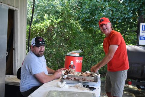 Megan Broome/The Clayton Tribune. Shawn McKay, left, and Mark Nelson volunteer at the Station 12 BBQ last weekend.