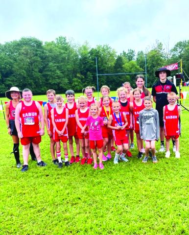 Courtesy of Ed Eidson. Head Coach Ed Eidson (right) and assistant head coach Holly Henry-Perry (left) pose with their team who all notched personal bests.