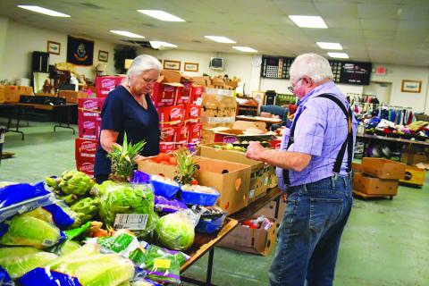 Megan Broome/The Clayton Tribune. Maryjane Webb Phillips and Carl Green volunteer at one of the Food Distributions held at the American Legion Post 220 last month. The food distribution is held every Thursday from noon-6 p.m.