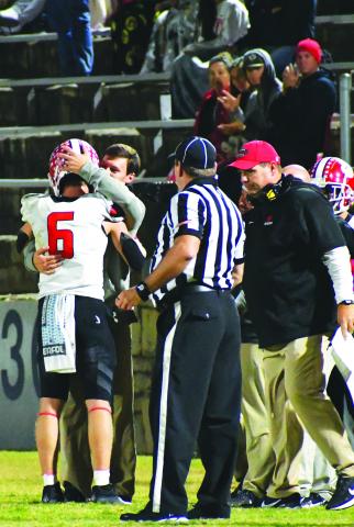 Luke Morey/The Clayton Tribune. Rabun County senior Jaden Gibson embraces passing coach Wes Holcombe after breaking two state records on Friday night. 