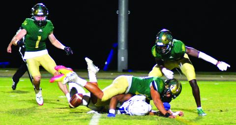 Enoch Autry/The Clayton Tribune. RGNS junior Huseyin Simsir (center) knocks the ball away from Charlotte Christian punt returner Micah Gilbert. Simsir collected the ball and then the Eagles added a field goal to push the score to 24-10.