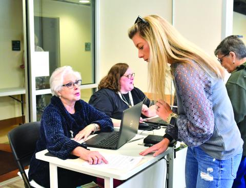 Megan Broome/The Clayton Tribune. Rabun County resident Laura Messer early votes at the Rabun County Board of Elections Office Tuesday. Poll workers Ann D’Agostino and Amanda Burrell are two of many poll workers who help voters navigate through the election process. Early voting continues through Nov. 4, with two opportunities for Saturday voting. Election Day is Tuesday, Nov. 8. 