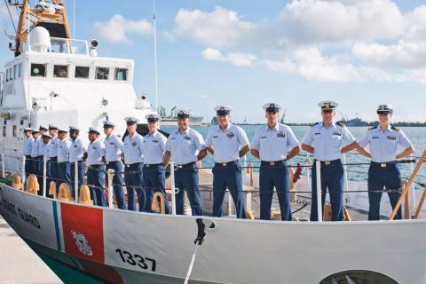 Photo courtesy of Sarah Ernst. Sarah Ernst (far right) stands aboard USCGC Assateague as the ship’s commander during her career with the U.S. Coast Guard.