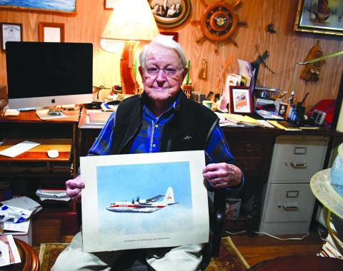 Megan Broome/The Clayton Tribune. Pilot and WWII Army veteran Capt. Douglas Day spends time in his Captain’s Quarters, among memorabilia from his lifetime of world travels as a pilot. Replicas of planes he once flew hang from the ceiling among globes, books, a map with pins of his world destinations, and other artifacts. Day also continues wood working. 