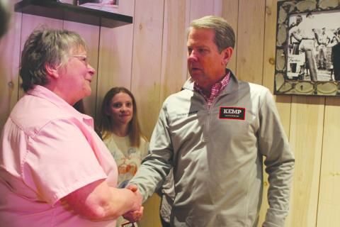 Megan Broome/The Clayton Tribune. Bonnie Edmonds of the Clayton Cafe shakes the hand of Gov. Brian Kemp during his campaign stop to Clayton in February.