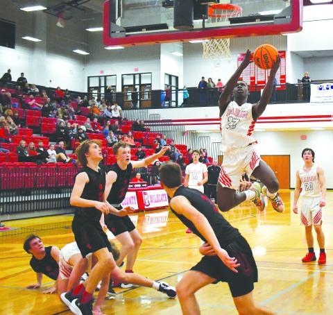 Luke Morey/The Clayton Tribune. With teammates junior Cooper Welch (14) and senior Jayton Henry (20) in the background, junior Willie Goodwyn goes up for a layup in the fourth quarter of Saturday’s game against Franklin, N.C. Goodwyn scored 12 points to help the Wildcats to a narrow 43-40 victory.