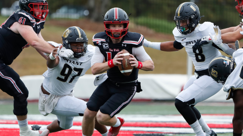 Courtesy of Gardner-Webb Athletics. Gardner-Webb redshirt senior Bailey Fisher evades two tackles in a game against Bryant on Oct. 29. Fisher, a former Rabun County Wildcat, threw for five touchdowns that day in the middle of his campaign to win Big South “Offensive Player of the Year.” 