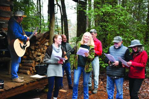 Enoch Autry/The Clayton Tribune. The choir from St. Helena’s Catholic Church perform Christmas carols. The choir members (from left) are musician Andres Santiago, Foxfire Assistant Curator Kami Ahrens, musician Eduardo Castro, and vocalists Chantal Gourlay, Andrew Timan, Stephan DeBlasio, and Luann Luedtke. 
