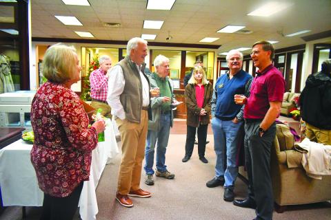 Megan Broome/The Clayton Tribune. Greg Funkhouser (right) and wife Cathee smile and laugh as they meet-and-greet community members at Rabun County Bank Dec. 14 for a retirement reception honoring his 43 years of service at the bank. 
