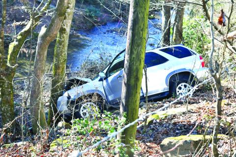 Megan Broome/The Clayton Tribune. This white 2001 Acura MDX struck a wire cattle fence and then a tree after traveling down an embankment during a single vehicle crash on Highway 76 West near Olas Lane in Clayton Nov. 28. Minor injuries were reported. 
