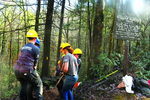 Megan Broome/The Clayton Tribune. Crew members with the Southeast Conservation Corps work together to carry large and heavy stones to a portion of the Bartram Trail at Warwoman Dell in order to build a set of stone stairs on the popular and highly-used trail. 