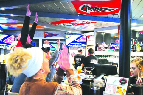 Luke Morey/The Clayton Tribune. Georgia Bulldog fans had plenty to celebrate on Monday night with a convincing 65-7 national championship win over TCU. Here local fans react to the TV broadcast of the first of two TD catches by UGA’s Ladd McConkey inside Clayton business Coach’s Bar and Grille.