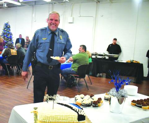 Megan Broome/The Clayton Tribune. Mountain City Police Chief Tom Garrison is all smiles as he cuts his cake at his retirement reception from the City of Mountain City on Dec. 30, 2022. Garrison retires after serving as a law enforcement officer for 28 years and Mountain City Police Chief for 18 years.