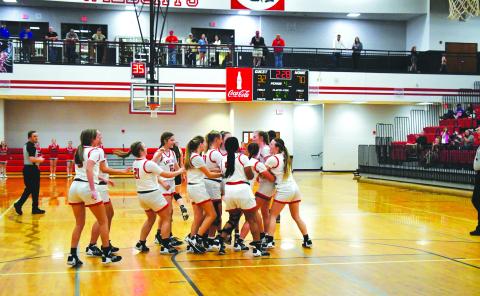 Luke Morey/The Clayton Tribune. RCHS junior Luc y Hood gets surrounded by her teammates after hitting two free throws to reach 1,000 career points. Hood ended with 25 points and was awarded a game ball for her 1,000 points. 