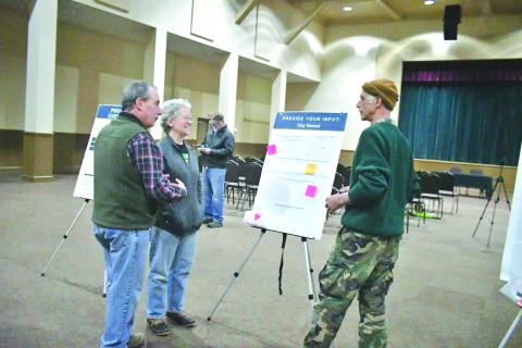 Megan Broome/The Clayton Tribune. Community members Joel Daniel and Frances Daniel (left) point to questions on the bulletin board and converse with Paul Vonk about what they want for the future of zoning.