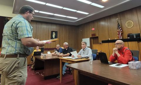 Megan Broome/The Clayton Tribune. Rabun County Zoning Administrator Shylan Wood speaks to commissioners during Tuesday’s work session about the zoning commission’s recommendation to approve with stipulations a rezoning request for 5 acres in Tiger from Agricultural (A) to Specific Purpose for the purpose of development of a covered storage facility. The vote by commissioners failed to pass due to lack of majority. 
