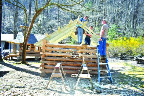 Megan Broome/The Clayton Tribune. Volunteer Tommy Thompson; Kami Ahrens, curator and director of education for Foxfire; and Barry Stiles, museum director, work to build the Ingram Mule Barn as the newest addition to the Children’s Village at the Foxfire Museum and Heritage Center. The scaled-down village for kids, modeled after existing buildings, is being built by hand using traditional tools like those used over 100 years ago. 