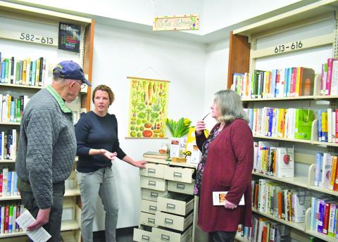 Megan Broome/The Clayton Tribune. April Biagioni (center) talks to David Ruth (left) and Vickie Prater about the Rabun County Seed Library and the different heirloom vegetable, herb, and flower seeds available to the public at the soft opening on March 16. 