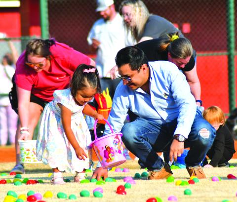 Daniel Contrevas helps his 3-year-old daughter Amalia during the Easter egg hunt.