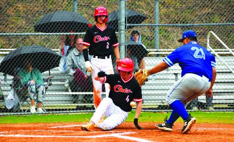 Luke Morey/The Clayton Tribune. With freshman Ty Truelove looking on, Rabun County senior Nathan Thompson slides into home plate on Thursday, April 13 against Barrow Arts and Sciences Academy.  
