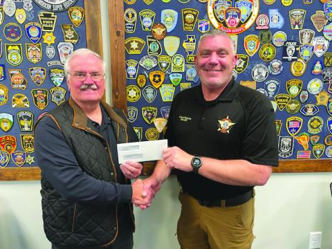 Submitted photo. Rotarian Lee Penland presents a $10,000 grant check from the Clayton Rotary Foundation, Inc. to Rabun County Sheriff Chad Nichols to support the sheriff’s office mental health initiative as it establishes a mental health unit within the office.