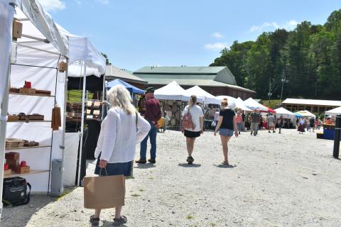Megan Broome/The Clayton Tribune. Teresa Weiser enjoys attending the Of These Mountains Spring MarketPlace last weekend and admires the handmade works of the artisans featured at the event. 