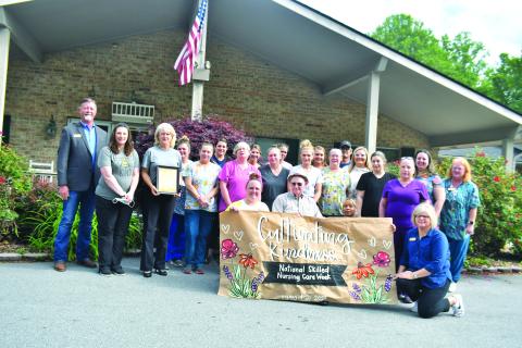 Megan Broome/The Clayton Tribune.  Nurses hold up a sign created by RCHS student Abbye Carver. Resident Ervin Chastain, who turns 100 years old in June, also enjoyed the presentation.   