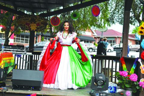 Megan Broome/The Clayton Tribune. Restaurant goers look on as Veronica Trejo, la leyenda hecha voz, performs traditional Mariachi style music at Universal Joint in Clayton to celebrate Cinco de Mayo Friday, May 5. While in traditional dress, Trejo sang and danced and interacted with the crowd as she celebrated the night away on the outdoor stage.