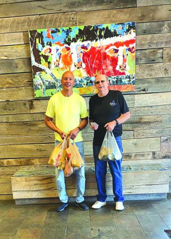 Photo courtesy of Larry Walker. Danny Burch presents the checks and a portion of the food donations to James Brim, manager of the Food Bank of Northeast Georgia Mountain Branch.