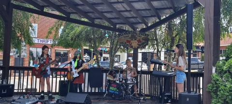 Megan Broome/The Clayton Tribune. The Neon Shadows, an all-girls rock group aged 9-10-years-old, performs a gig at Universal Joint July 16.  The band plays covers and six original songs inspired by their lives titled “Little Ghost,” “Mixed Up,” “Gravity Falls Down,” “Timmy Vibes,” “Reflect the Moon,” and “Surface of the World.” 