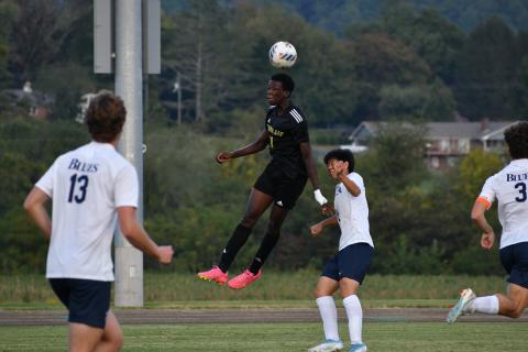 Wade Cheek/The Clayton Tribune. Eagle senior forward Theo Ochieng soars above Blues defenders for a header against region opponent Asheville School. RGNS is currently the No. 2 team in the NCISAA 4A division. 