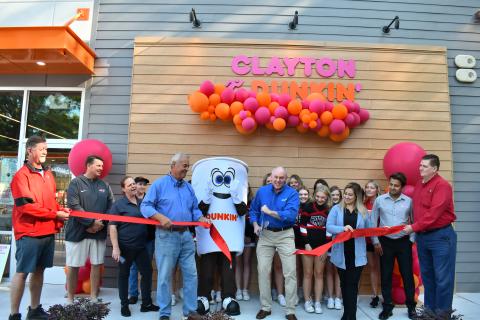 Megan Horn/The Clayton Tribune. The community showed out as Dunkin’ Donuts in Clayton held its official ribbon cutting and grand opening with Forward Rabun/Rabun County Chamber of Commerce Sept. 30. Below: Megan Horn/The Clayton Tribune. Lucy Woerner poses with Cuppy during the Sept. 30 Dunkin' Donuts grand opening. 