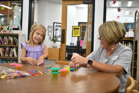 Megan Horn/The Clayton Tribune. Kate Getty, 4, has fun making Play-Doh creations with Kim Cannon, Children’s Services, during the “1,000 Books Before Kindergarten” kickoff event at the Rabun County Public Library Sept. 21. 