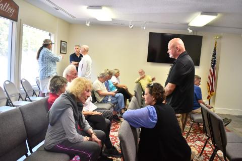 Megan Horn/The Clayton Tribune. Sky Valley Chief of Police Vaughn Estes converses with community members at Tuesday’s emergency called council meeting as many people came out to support Estes after he was suddenly terminated Oct. 2.