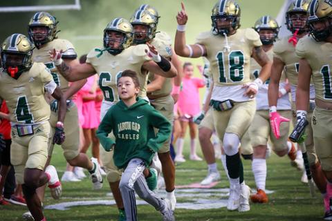 RGNS Athletics. RGNS football players and young fans sprint onto the field, dressed in pink, before the Eagles’ 57-22 victory over Metrolina Christian. RGNS is now 8-0 for the first time in program history. 