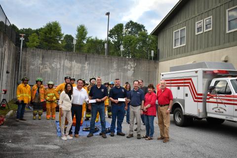 Megan Horn/The Clayton Tribune.  Pictured are Debi Bock and David Bock with Highlands Festival, Inc.; Chief Ken Sigler; Assistant Chief Jamie Chastain; Jeff Marlow and Debra Marlow with Windfield Development; Steve Mehder with with Highlands Festival, Inc.; and firefighters from Sky Valley-Scaly Mountain Volunteer Fire & Rescue. Not pictured are Nancy and Rebecca Maddox with Windfield Development. 