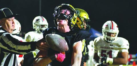 Wade Cheek/The Clayton Tribune. Rabun Gap’s Trey Horne, a Georgia Tech commit, vocally reacts after scoring a touchdown in the NCISAA state championship game as the referee reaches in grasp Horne’s arm with the ball. The Eagles fell 34-27 in the contest to Providence Day.