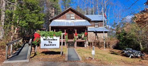 Megan Horn/The Clayton Tribune. The front entrance to Foxfire at 98 Foxfire Lane in Mountain City is decorated with garland and seasonal red bows. On Saturday, Dec. 16, the location will showcase several holiday-oriented Appalachian aspects.