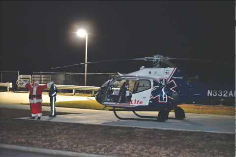 Megan Horn/The Clayton Tribune. Santa arrives at Mountain Lakes Medical Center by helicopter Dec. 14 and waves to a crowd of children jumping up and down in excitement. 